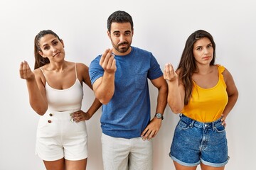 Sticker - Group of young hispanic people standing over isolated background doing italian gesture with hand and fingers confident expression