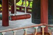 Closeup of a bronze bell and striker in a pavilion in a Buddhist temple