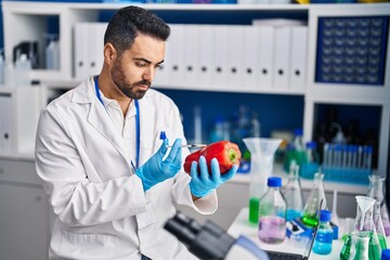 Sticker - Young hispanic man scientist analysing red pepper at laboratory