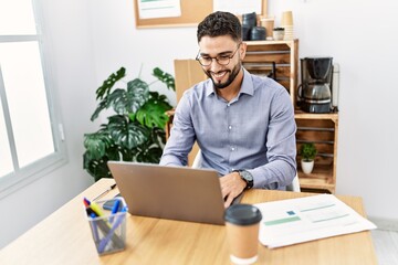 Sticker - Young arab man smiling confident using laptop working at office