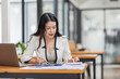 © David - Female Business Asian working on documents on laptop in the workplace, Young asian woman sitting at table doing planning financial report, business plan investment, finance analysis concept.