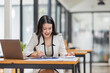 © David - Female Business Asian working on documents on laptop in the workplace, Young asian woman sitting at table doing planning financial report, business plan investment, finance analysis concept.