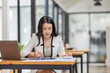 © David - Female Business Asian working on documents on laptop in the workplace, Young asian woman sitting at table doing planning financial report, business plan investment, finance analysis concept.