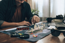 Wood Box With Word " Travel" On World Map And Travelers Planning Use Small Wood Doll To Marking On Map And Finger Pointing On Map, Or Find Travel Routes. Travel Concept.