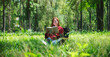 © Farknot Architect - Portrait of a beautiful young asian woman reading a book while sitting on a camping chair in the park
