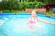 © Анна Молько - A child in the water. A girl splashes in an inflatable pool in the garden on a sunny summer day. High quality photo