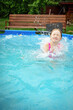 © Анна Молько - A child in the water. A girl splashes in an inflatable pool in the garden on a sunny summer day. High quality photo
