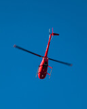 Fototapeta  - czerwony helikopter na niebieskim niebie 