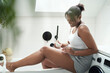© gpointstudio - Unrecognizable African-American woman sitting on bath and applying moisturizing cream