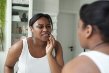 African-American Woman  In The Bathroom Having A Strong Toothache Or Bruxism