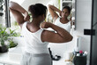 © gpointstudio - African-American woman standing in the domestic bathroom and stretching