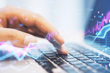 Canvas Print - hands using laptop computer keyboard with abstract glowing candlestick forex chart with index and grid on blurry background. Invest, trade, finance ans stock market concept. Double exposure.