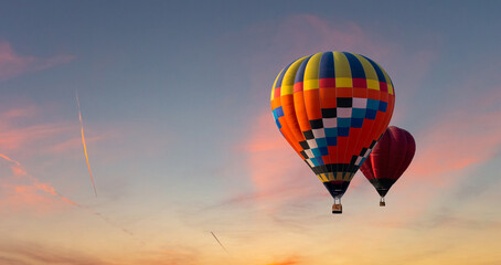 Colorful hot air balloons flying on the sunset sky background.