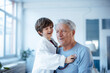© Westend61 - Happy boy imitating as doctor checking grandfather with stethoscope at home