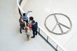 © Westend61 - Multiracial business colleagues planning strategies by peace symbol in office corridor