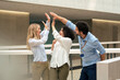 © Westend61 - Happy business colleagues giving high-five in corridor