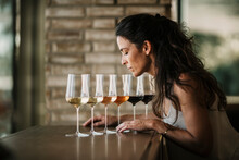 Mature Woman Smelling Wines In Glasses At Restaurant