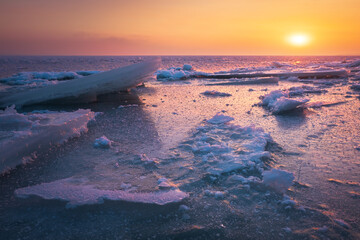 Wall Mural - Sunrise and frozen sea. Beautiful winter landscape with lake and red sun in morning time. Daybreak