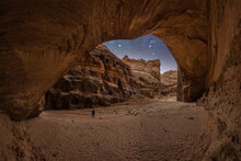 Tourist In Between Stone Arch And Canyon Under Starry Sky With Milky Way