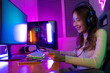 © Kiattisak - Top up online game with credit card concept. Gamer and E-Sport online of Asian woman playing online computer video game with lighting effect, broadcast streaming live at home. Gamer and E-Sport gaming