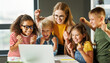 © JenkoAtaman - Teacher and cheerful  schoolkids   looking at laptop screen and celebrate   successful completion of collective school work   during online lesson