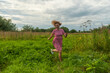 © Dmitry - a girl with fluttering hair in the wind in a red dress runs through a meadow with green grass.