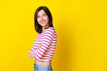 Sticker - Photo portrait of cheery confident young girl look empty space crossed arms wear trendy striped garment isolated on yellow color background