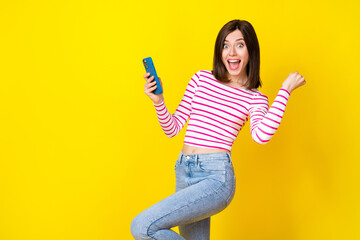 Wall Mural - photo portrait of lovely young lady hold device raise fist win lottery dressed trendy striped garmen