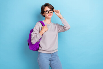 Poster - Portrait of pretty cheerful smart girl nice outfit hold bag touch eye accessory stand empty space isolated on blue color background