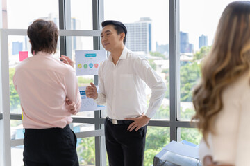 Wall Mural - A group of Asian businessmen in casual wear are having a meeting to present their ideas on how to run a sustainable small business SME