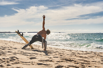 Man stretching in the morning and admiring beautiful view while standing next to the sea