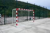 handball or soccer goal on a concrete court closed by a high metal fence