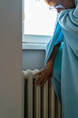 Senior woman feeling cold at home with home heating trouble