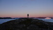 © robb - Person standing on cliff overlooking icebergs in Greenland