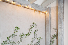 Wall Of Room Is Decorated With Garland And Ivy. Wooden Beams Inside The House