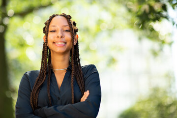 Wall Mural - Close up portrait of pretty young black woman outside