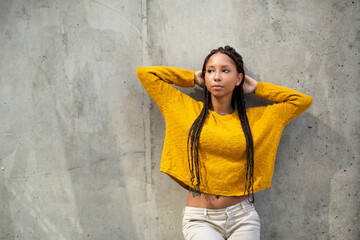 Wall Mural - Portrait of fashionable young african american woman posing by a wall