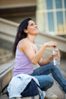 © mimagephotos - Happy woman sitting with water bottle no steps