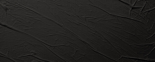 Empty crumpled wet black paper blank texture copy space wall background.