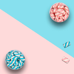 Two pots with colorful marshmallows on blue and pink background and copy space