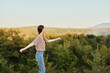© SHOTPRIME STUDIO - A young woman stands with her back to the camera in a T-shirt and jeans in nature and admires a beautiful view of the mountains