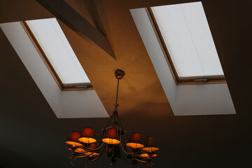Aufkleber - Pleated blinds automatic on roof windows close up in the interior. Motorized blinds for skylights. White color.