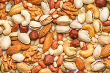 Background From Different Types Of Nuts And Seeds - Peeled Walnut, Hazelnuts, Peeled Peanut, Pine Nut Kernels, Almond Seeds, Cashew Seeds, Pistachio Nuts In The Shell, Pumpkin Seeds