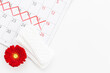 Calendar with red marks and white pad. Menstruation period concept