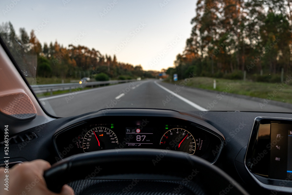 Driver view to the speedometer at 87 kmh or 87 mph and the road blurred ...