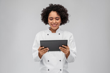 Wall Mural - cooking, culinary and people concept - happy smiling female chef in white jacket with tablet pc computer over grey background