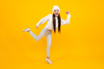 Canvas Print - Excited face. Amazed expression, cheerful and glad. Full length little overjoyed teen girl 12, 13, 14 year old jump and run isolated on yellow background studio.