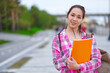 © Joe-L - Smiling Asian Female Student with Folders and backpack in green summer park. education, campus and teenage concept