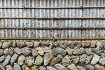 Poster - Stone wall and bamboo fence for pattern and background