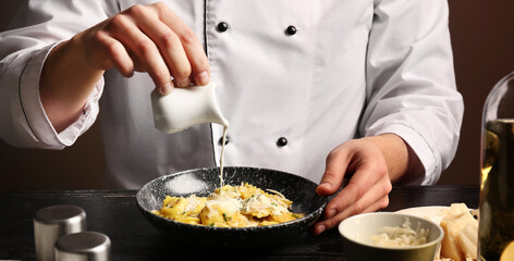 Male chef preparing tasty ravioli for serving, closeup